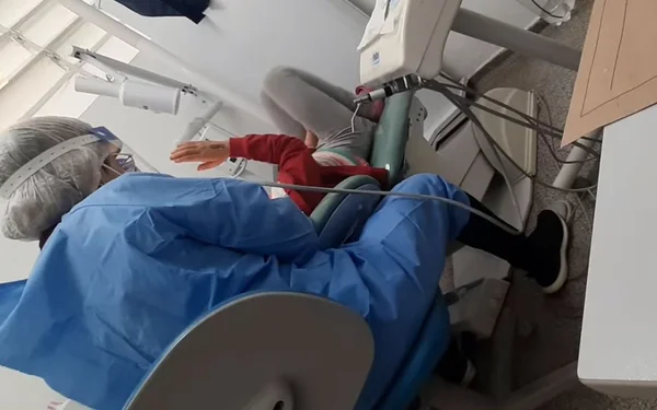 foto colorida de criança recebendo atendimento odontológico