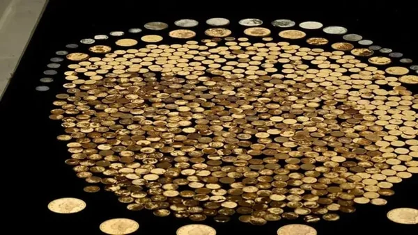 imagem colorida com moedas de ouro espalhadas em uma mesa preta - Metrópoles
