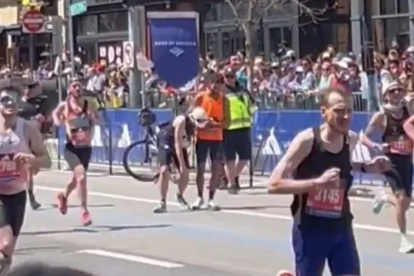Foto colorida do momento em que brasileiro auxilia corredor na Maratona de Boston - Metrópoles
