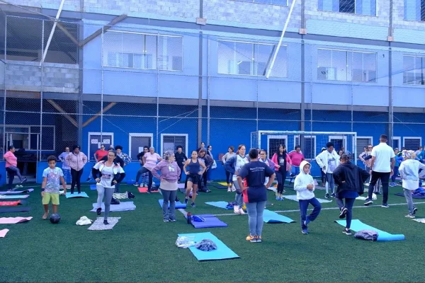 foto colorida de pessoas em pé ao lado de tapetes de yoga - Metrópoles
