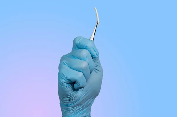 Foto de mão com luva segurando Implante hormonal - Metrópoles