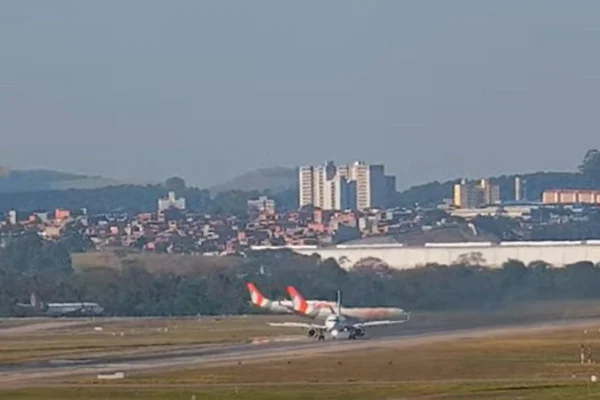 Imagem colorida mostra avião da Latam soltando fumaça preta no aeroporto de Guarulhos - Metrópoles