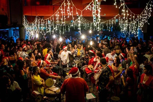 foto colorida de roda de samba com pessoas vestidas de papai noel - metrópoles