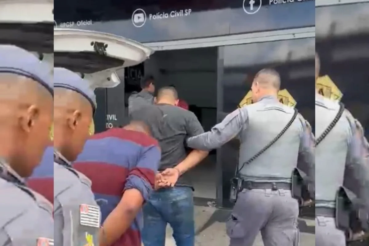 Foto colorida de homens sendo conduzidos por policiais militares (PMs) na Região Metropolitana de São Paulo.