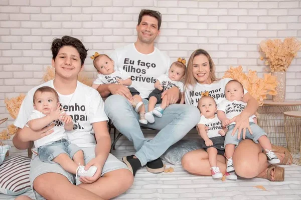 Foto colorida de família com os quíntuplos capixabas - Metrópoles