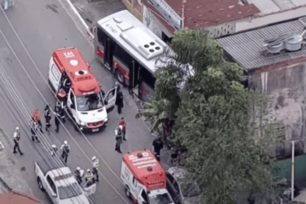 Imagem colorida de um ônibus batido em um poste com diversas ambulâncias ao redor - Metrópoles