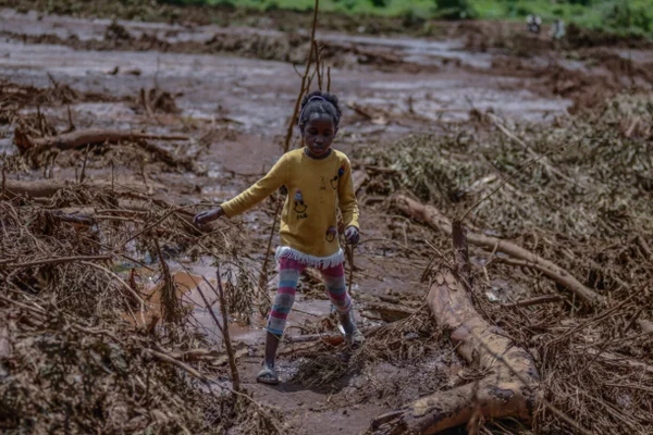 Foto colorida de criança em meio à terra - Metrópoles
