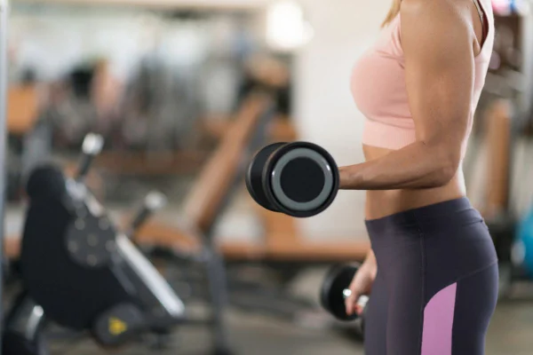 mulher levantando um halter na academia