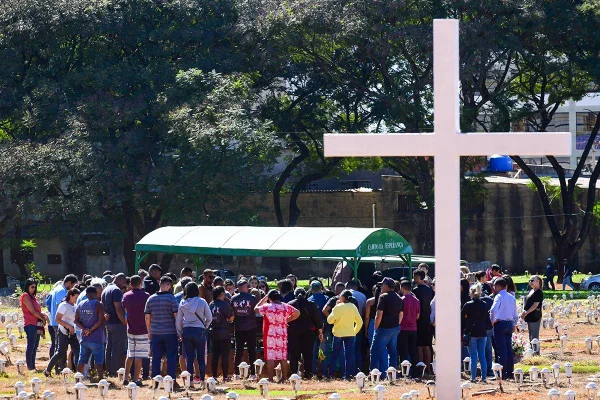 Foto colorida tirada de dia de velório em cemitério ao ar livre