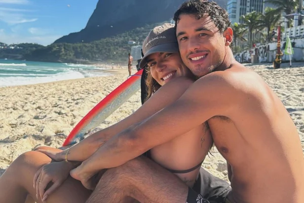 Mariana Goldfarb e o namorado, Rafael Kemp, posam juntos e sorridentes na praia - Metrópoles