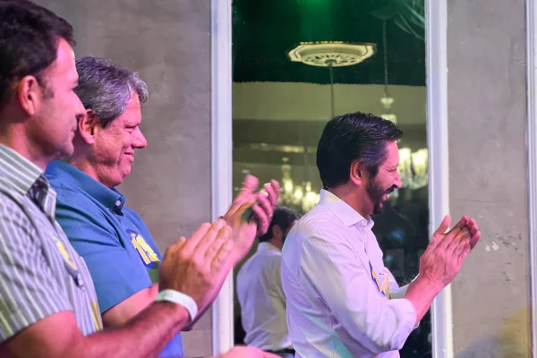 Imagem colorida mostra Ricardo Nunes e Tarcísio de Freitas no palco do Bar Brahma
