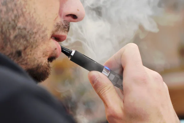 Homem em close up fumando cigarro eletronico vapes
