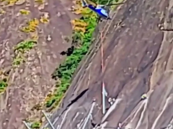 Foto colorida de helicópetero colocando barreira no morrro Dois Irmãos (RJ) - Metrópoles
