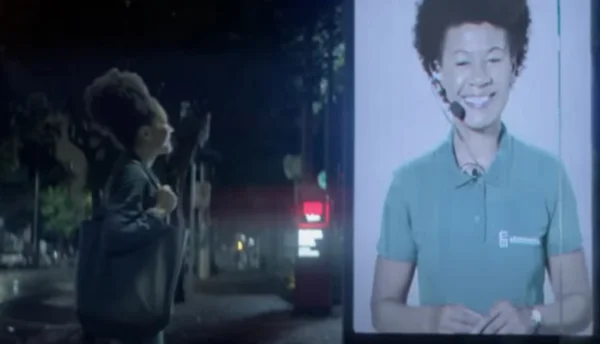 Imagem colorida mostra mulher em ponto de ônibus em videochamada com atendente da Eletromídia, no projeto Abrigo Amigo. Metrópoles