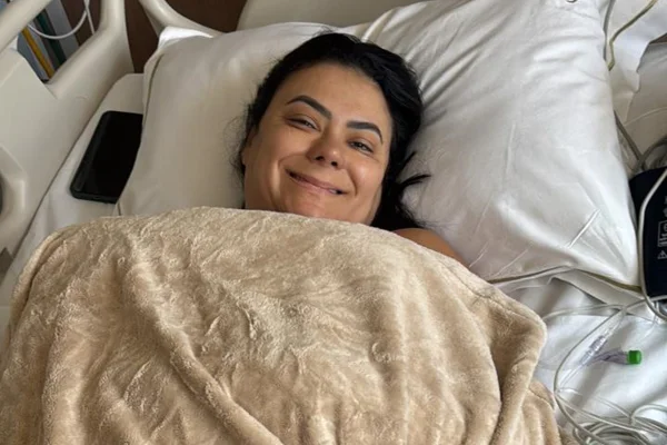Foto colorida de mulher deitada em maca hospitalar - Metrópoles.