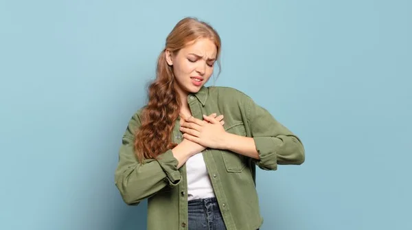 Mulher iludida, sofrendo de amor, com a mão no coração