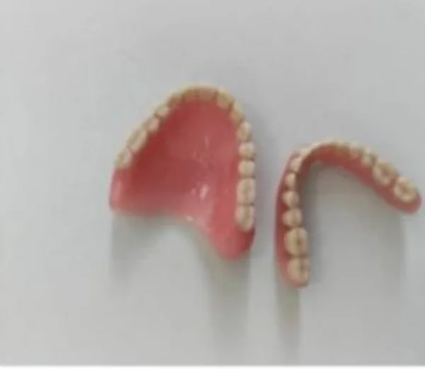 Imagem mostra par de dentaduras em fundo branco - Metrópoles