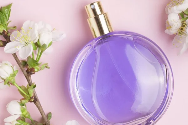 perfume roxo com uma flor de lavanda do lado em um vidro redondo - Metrópoles