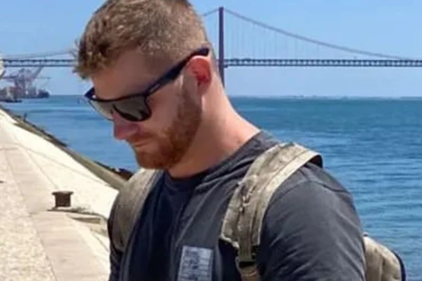Ex-produtor da Record, Elian Matte posa de óculos escuros e com uma mochila durante viagem - Metrópoles