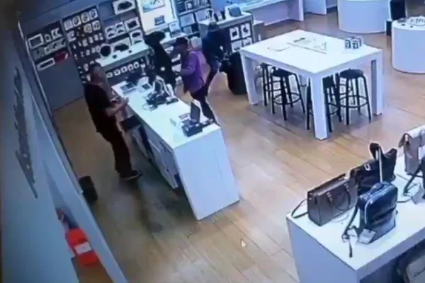 Imagem colorida de ladrões roubando loja de celulares. Metrópoles