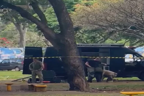 Van do Bope estacionada em praça com policial vestindo roupa anti-bomba