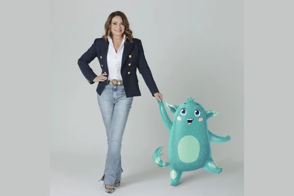 Mulher posando para a foto de mãos dadas com um boneco virtual - Metrópoles