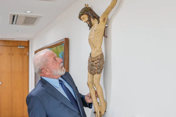 Imagem colorida do presidente Lula com a estátua de Cristo, que fica em seu gabinete no Palácio do Planalto - Metrópoles