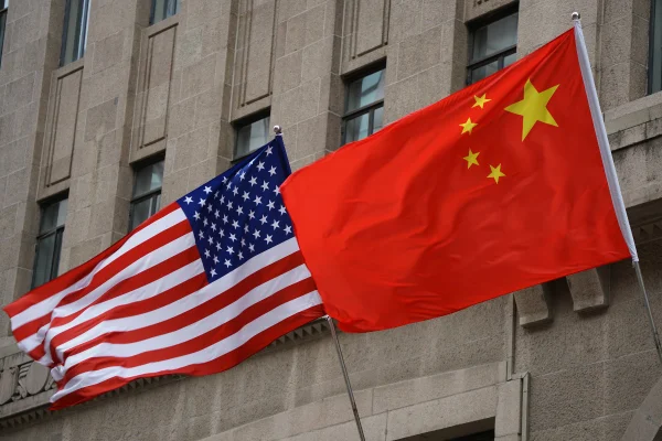 Foto colorida mostra as bandeiras da China e dos Estados Unidos hasteadas lado a lado