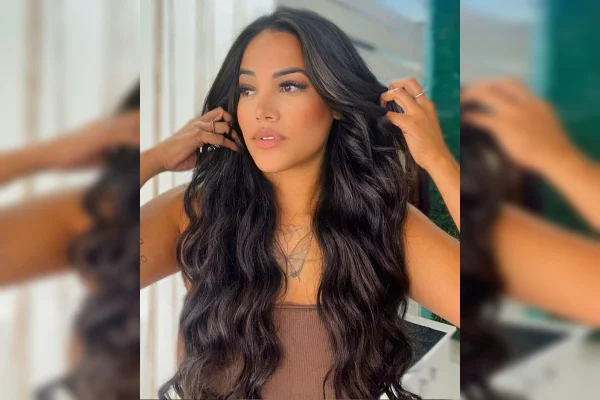 Imagem colorida de uma mulher de cabelos pretos e blusa marrom