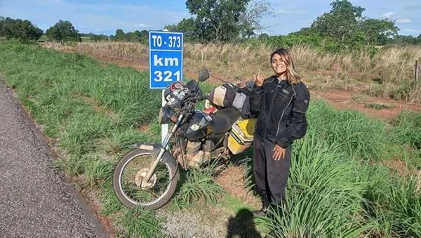 Motociclista posa para foto em margem de rodovia