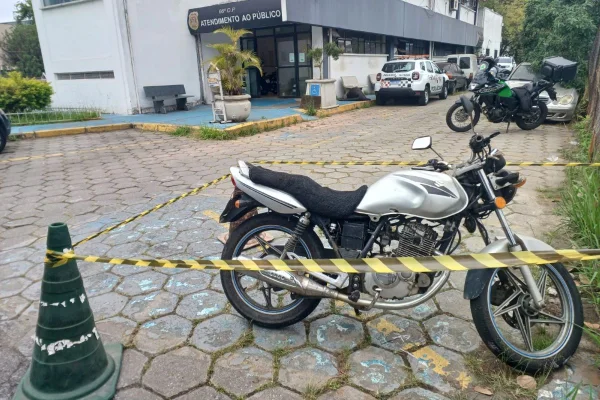 Imagem colorida de moto estacionada com banco sujo de sangue - Metrópoles
