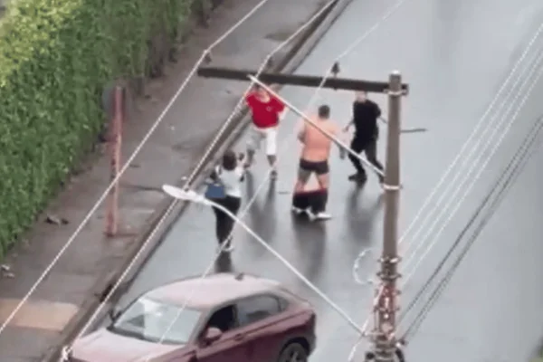 Imagem colorida de três homens e uma mulher em uma briga de trânsito - Metrópoles