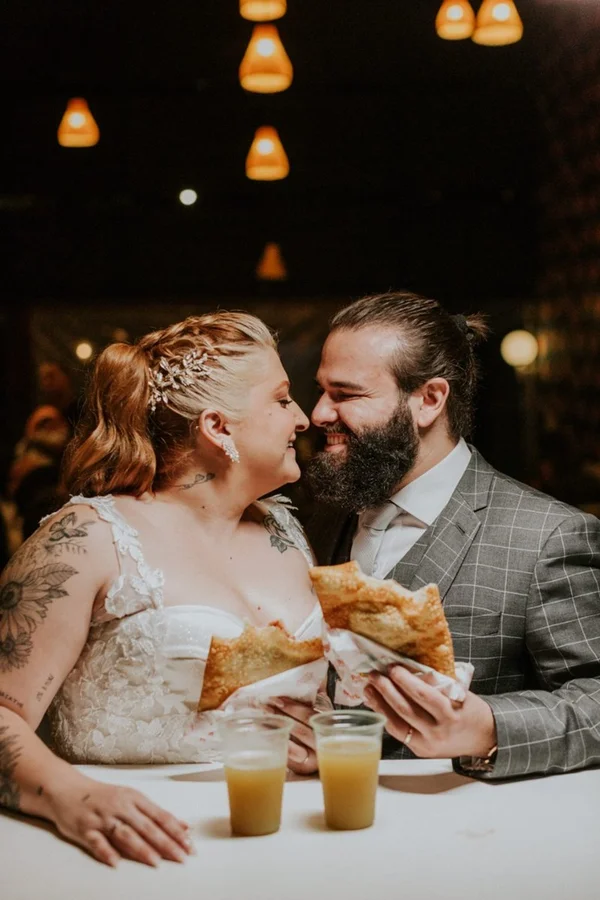 Casal come pastel com caldo de cana em celebração de casamento