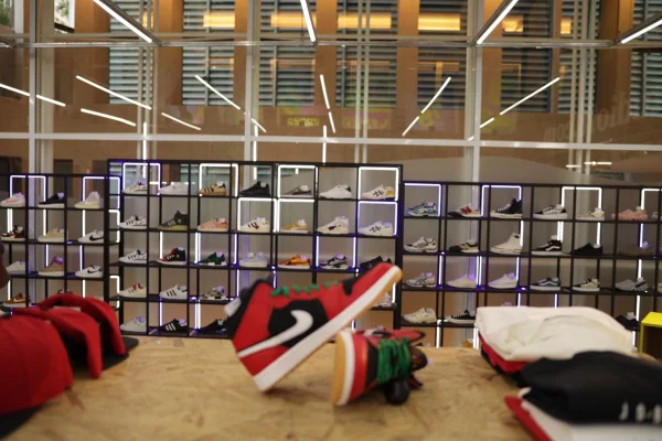 Tênis vermelho em destaque com outros sneakers ao fundo em loja - Metrópoles