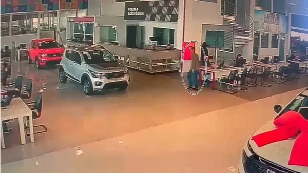 homem andando dentro de loja de veículos