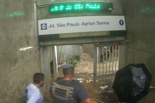 Imagem colorida de policial militar entrando em estação de metrô alagada