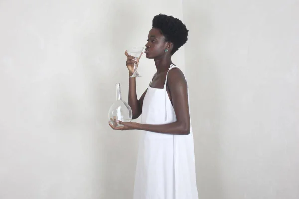 Modelo usa vestido branco com alças em fundo branco