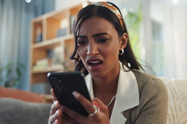 mulher indignada olhando pro celular