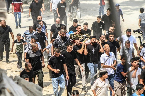 Pessoas carregam os corpos de vários palestinos, entre os cinco mortos em um ataque aéreo israelense no campo de refugiados de Nour Shams
