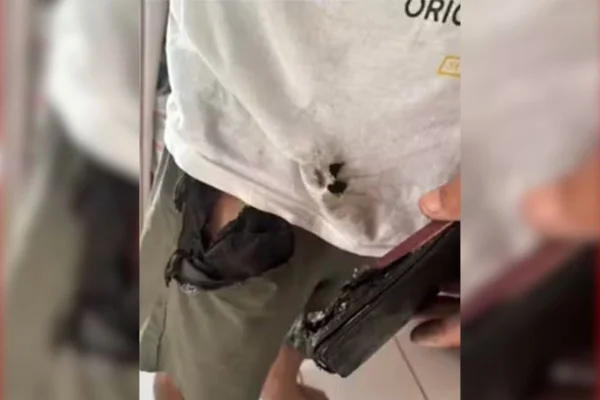 Foto colorida de roupas e aparelho celular após a explosão - Metrópoles