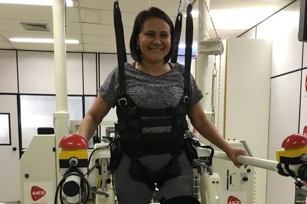 Foto colorida de mulher usando colete de reabilitação após cirurgia de escoliose - Metrópoles