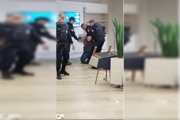 Imagem colorida de homem sendo imobilizado por PMs