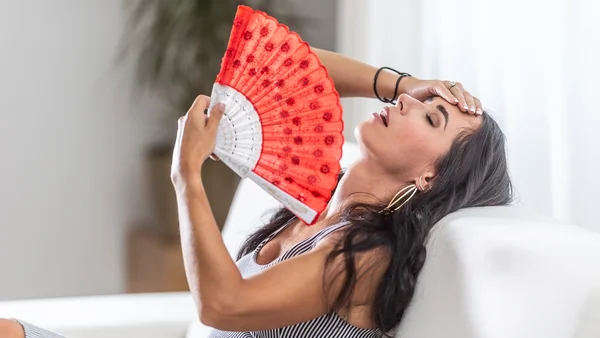 mulher sofrendo com o calor em casa