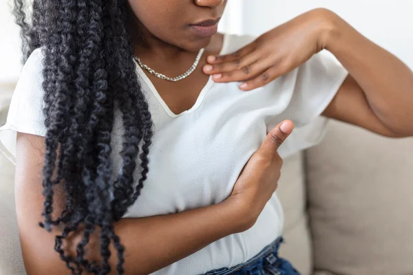 Imagem colorida de uma mulher negra fazendo autoxame de mama - Metrópoles