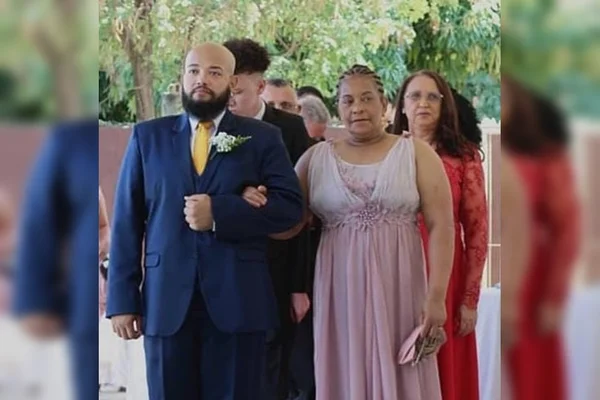Homem de terno ao lado de idosa de vestido rosa claro
