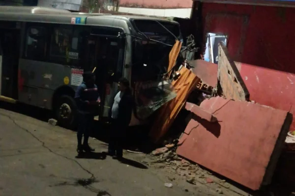 Imagem colorida mostra ônibus municipal danificado após colisão contra comércio. Metrópoles