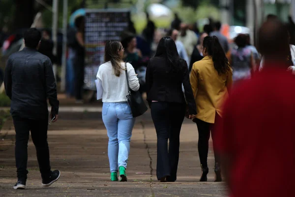 Fotografia colorida de trabalhadores andando na rua