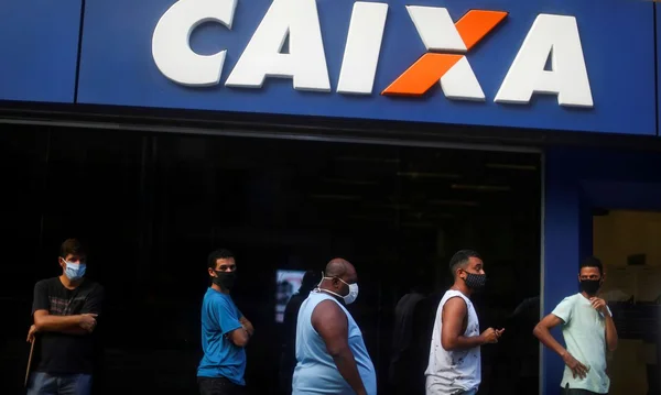 Pessoas em frente a uma agência da Caixa
