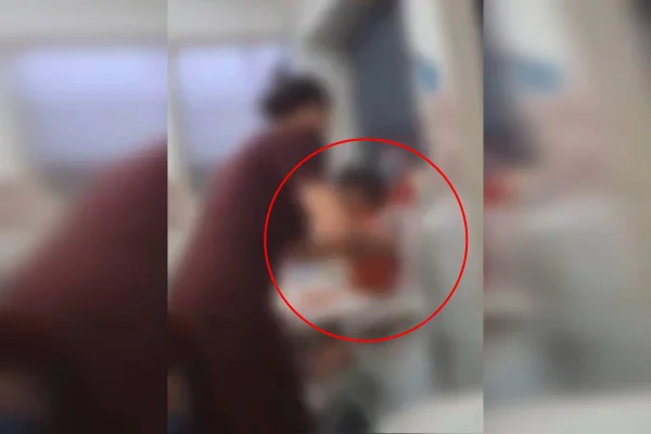 Foto colorida e borrada que mostra a proprietária agredindo uma menina de 1 ano, em uma creche no DF