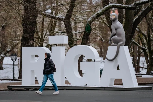 Imagem colorida de monumento da cidade de Riga com estátua do gato em cima